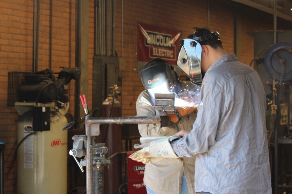 two high school students enrolled in CTE are demonstrating their welding skills